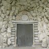 Saline royale d'Arc-et-Senans - sous le portique du bâtiment des gardes, un portail inscrit dans un décor de rochers.