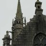 Eglise Saint Miliau - détail du clocher-tour de style Beaumanoir. Le clocher gothique (pyramide octogonale ajourée) est flanqué d'une tourelle ronde.