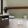 La salle de bain : meuble lavabo design, baignoire et douche.