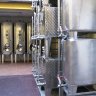 Distillerie Metté - Les cuves en inox dans une cour, à l'air libre. Les variations de température sont utiles à l'excellence des eaux de vie. La chaleur estivale permet l'évaporation alcoolique et le froid hivernal favorise le filtrage des impuretés résiduelles qui se déposent au fond des  cuves.   