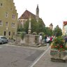 Fontaine dans la Herrngasse (Herrnbrunnen) devant l'église des Franciscains (Franziskanerkirche - à voir le jubé, sculptures des XVe et XVIe siècles). Au fond, la Burgtor (porte du château).